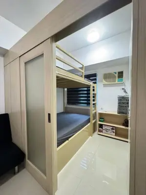 a small bedroom with a bunk bed in it at Cozy condo by the MRT & Light Mall experience comfort and convenience in Manila