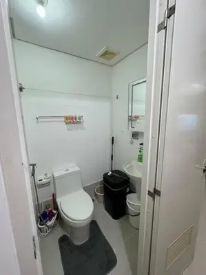 a white bathroom with a toilet and a sink at Cozy condo by the MRT & Light Mall experience comfort and convenience in Manila