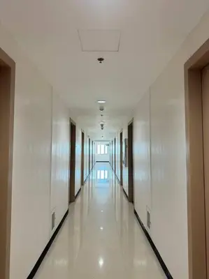 a hallway of a building with white walls and white floors at Cozy condo by the MRT & Light Mall experience comfort and convenience in Manila