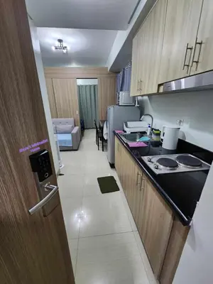 a kitchen with a refrigerator and a counter top at SHORE 2 Residences MOA in Manila