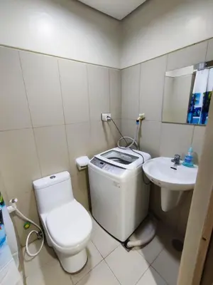 a small bathroom with a toilet and a sink at Breeze Residences Manila in Manila