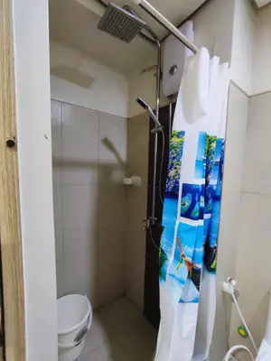 a bathroom with a shower and a toilet at Breeze Residences Manila in Manila