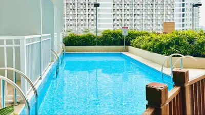 a swimming pool on the roof of a building at Breeze Residences Manila in Manila
