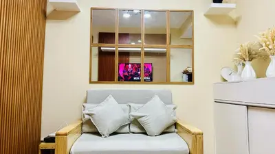 a couch with pillows on it in a room at Breeze Residences Manila in Manila