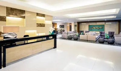 a lobby of a hotel with couches and chairs at Breeze Residences Manila in Manila