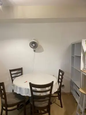 a white table with chairs and a fan on the wall at SOHO Central 1 Bedroom with Balcony near MRT EDSA SHAW PIONEER Greenfields SM Megamall Ortigas in Manila