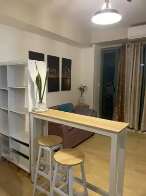 a kitchen with a counter with two stools and a table at SOHO Central 1 Bedroom with Balcony near MRT EDSA SHAW PIONEER Greenfields SM Megamall Ortigas in Manila