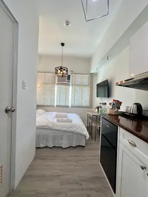 a bedroom with a bed in the middle of a room at Studio One Condominium, Alabang - Bluu - Fiber Wi-Fi, Netflix-ready in Manila