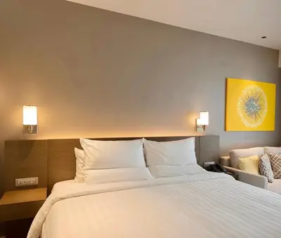 a bedroom with a large bed with white pillows at The Hotel at Tower Acqua 1 in Manila