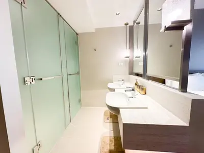a bathroom with two sinks and a glass shower at The Hotel at Tower Acqua 1 in Manila