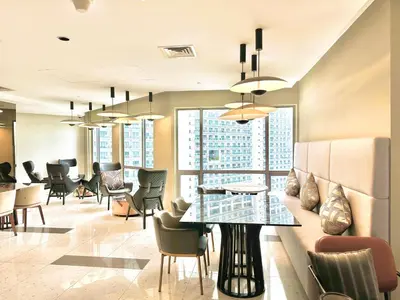 a lobby of a hotel with a table and chairs at The Hotel at Tower Acqua 1 in Manila