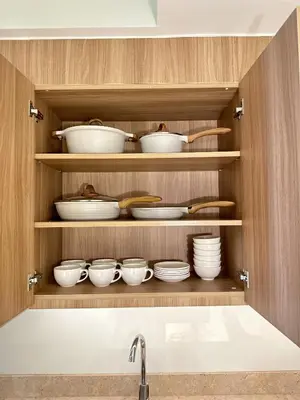 a kitchen cabinet with bowls and utensils at The Hotel at Tower Acqua 1 in Manila