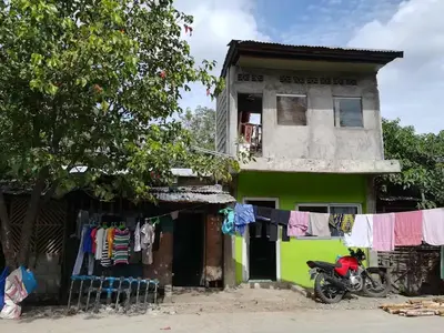 a motorcycle parked in front of a house with clothes hanging on a line at Neighborhood Maricaban Pasay Rent in Manila