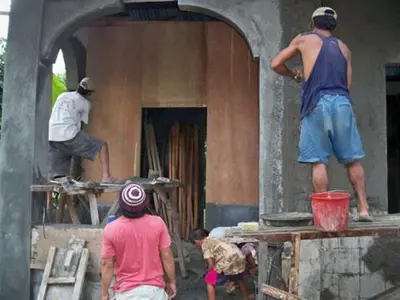 a group of people are working on a building at Neighborhood Maricaban Pasay Rent in Manila
