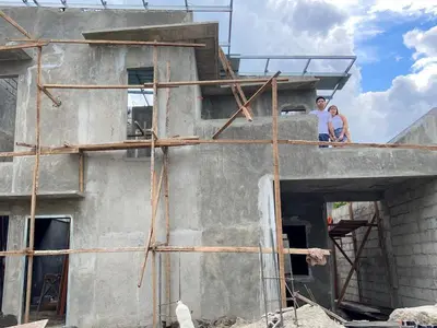 two people standing on a building under construction at Neighborhood Maricaban Pasay Rent in Manila
