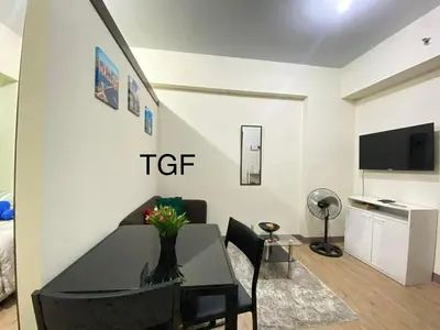 a living room with a table and a dining room at transient room anuva condominium in Manila
