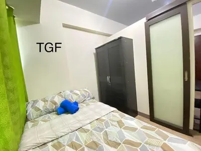 a bedroom with a bed with a blue stuffed animal on it at transient room anuva condominium in Manila