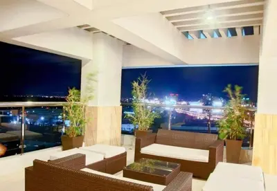 a living room with a view of a city at night at transient room anuva condominium in Manila