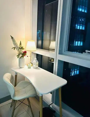 a white table and chair with a lamp and a window at Taguig Parksuit 1BGC in Manila
