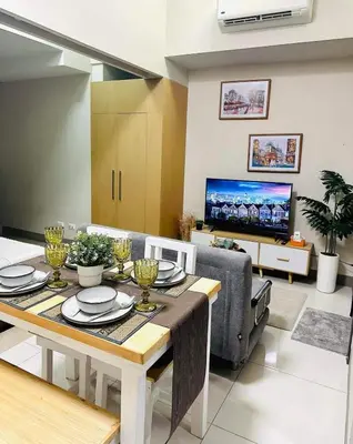 a living room with a dining table and a tv at Taguig Parksuit 1BGC in Manila
