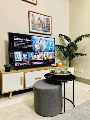 a living room with a large tv and a table at Taguig Parksuit 1BGC in Manila