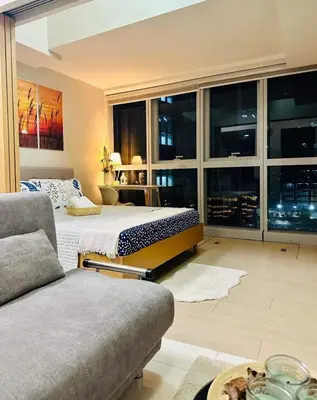a large bedroom with a bed and a couch at Taguig Parksuit 1BGC in Manila