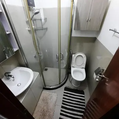 a bathroom with a shower and a toilet and a sink at Quaint One Br Apartment in Manila