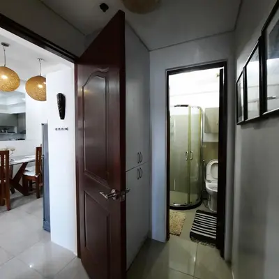 a bathroom with a wooden door and a toilet at Quaint One Br Apartment in Manila