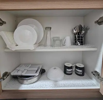 a shelf with plates and other dishes in a kitchen at DreamEscape by Charm Residences in Manila