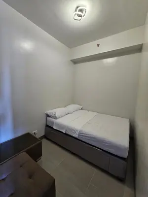 a small bedroom with a bed and a couch at DreamEscape by Charm Residences in Manila