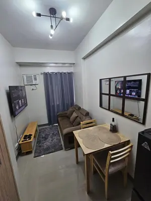 a living room with a table and a couch at DreamEscape by Charm Residences in Manila