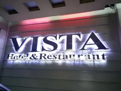 a sign for a hotel and restaurant on a wall at Vista Hotel Recto in Manila