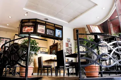 a restaurant with a table and chairs and a clock at Majestic Hotel Manila - Formerly Octagon Mansion Hotel Manila in Manila