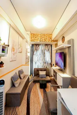a small living room with a couch and a tv at Sapphira Manor Luxurious Condo by the Bay in Manila