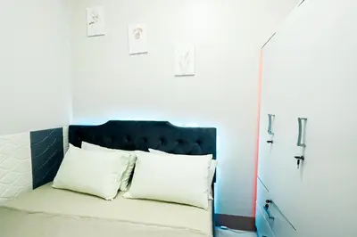 a bed with a blue headboard and white pillows at Sapphira Manor Luxurious Condo by the Bay in Manila