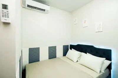 a bedroom with a bed with a blue headboard at Sapphira Manor Luxurious Condo by the Bay in Manila