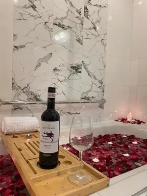 a bottle of wine and a wine glass on a wooden tray at QUITE Euro Luxe 3BR 7 mins walk to high street in Manila