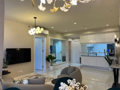 a living room with a couch and a tv at QUITE Euro Luxe 3BR 7 mins walk to high street in Manila