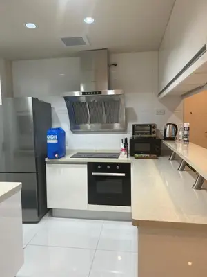a large kitchen with a stove and a refrigerator at QUITE Euro Luxe 3BR 7 mins walk to high street in Manila