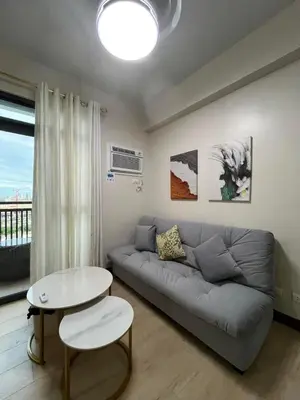 a living room with a couch and a table at Gentry Manor Family Suite Balcony City View WiFi Netflix close to Okada 12B in Manila