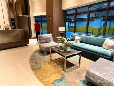 a lobby with a blue couch and a table and chairs at Gentry Manor Family Suite Balcony City View WiFi Netflix close to Okada 12B in Manila
