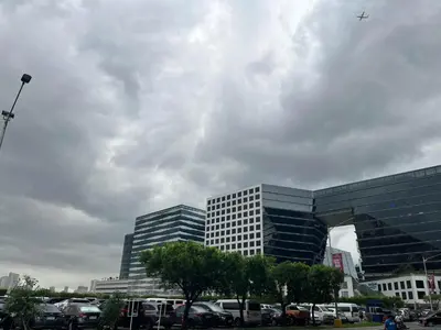a plane flying over a parking lot in front of buildings at Gentry Manor Family Suite Balcony City View WiFi Netflix close to Okada 12B in Manila
