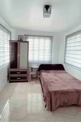a bedroom with a bed and a cabinet and a table at Modern Home Near MOA and NAIA in General Trias