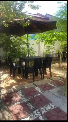 a table and chairs under an umbrella on a patio at Modern Home Near MOA and NAIA in General Trias