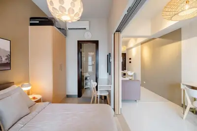a bedroom with a bed and a dining room at Uptown BGC in Manila