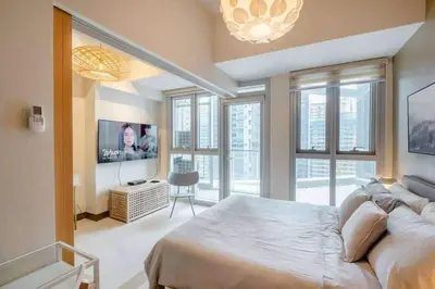 a bedroom with a large bed and a tv at Uptown BGC in Manila