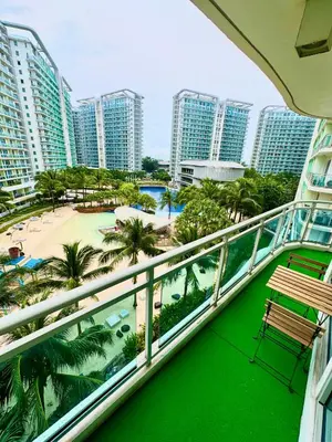 a balcony with a view of a beach and buildings at Aesthetic Beach View Unit in Azure Parañaque in Manila