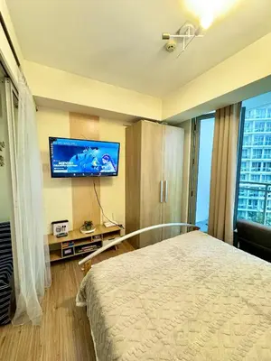 a hotel room with a bed and a flat screen tv at Aesthetic Beach View Unit in Azure Parañaque in Manila