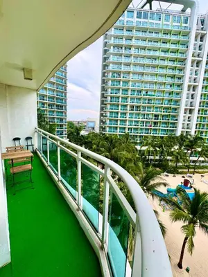 a balcony with a view of a beach and buildings at Aesthetic Beach View Unit in Azure Parañaque in Manila