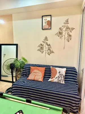 a bed in a room with a pool table at Aesthetic Beach View Unit in Azure Parañaque in Manila